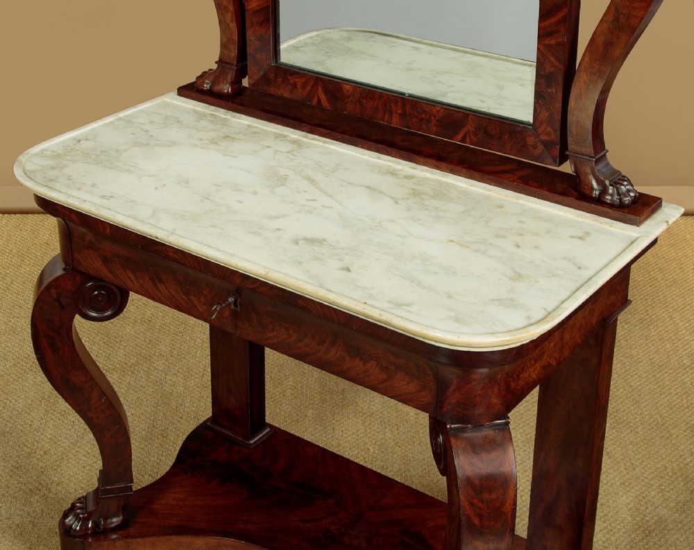 A mid-19th-century mahogany dressing table featuring a white marble surface, arched swing mirror on carved scroll supports, and lower plinth base. View VII