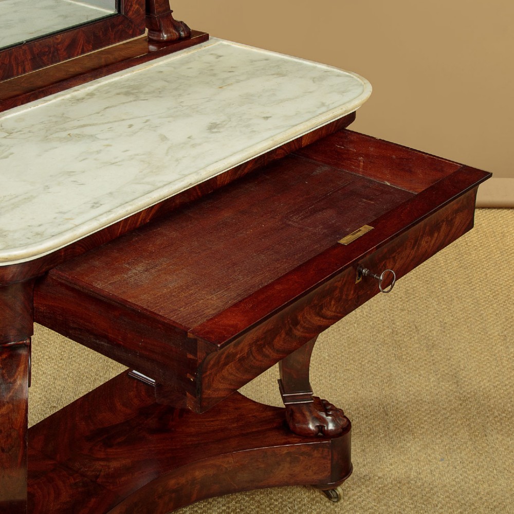 A mid-19th-century mahogany dressing table featuring a white marble surface, arched swing mirror on carved scroll supports, and lower plinth base. View IX