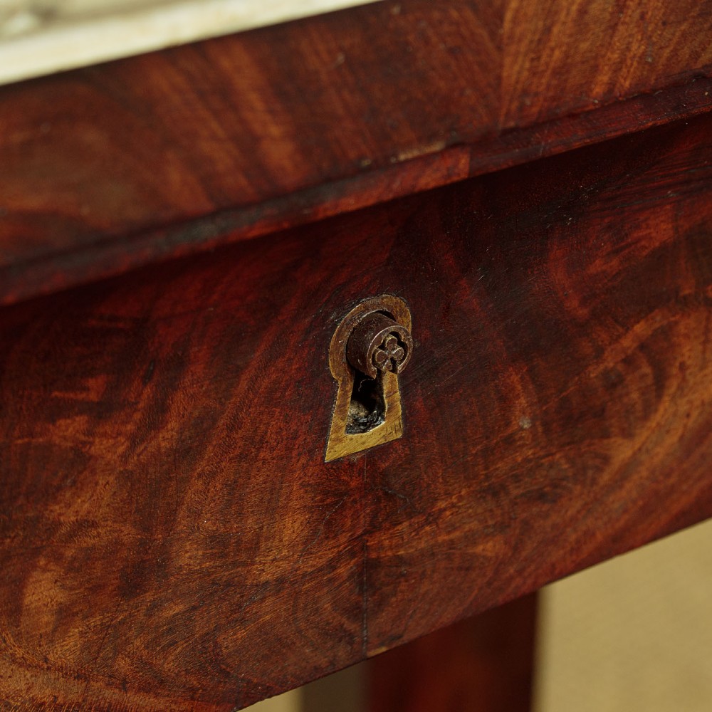 A mid-19th-century mahogany dressing table featuring a white marble surface, arched swing mirror on carved scroll supports, and lower plinth base. View X
