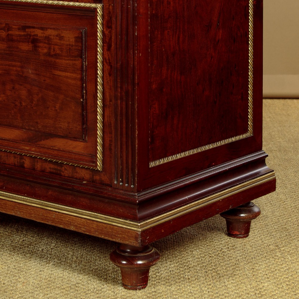 A large Edwardian mahogany breakfront bookcase featuring three sections with brass mesh doors, decorative brass mounts, and a central projecting stepped section. View IX