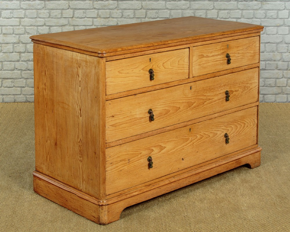 A late Victorian natural pine chest of drawers featuring a two short over two long drawer layout with brass drop handles. View III