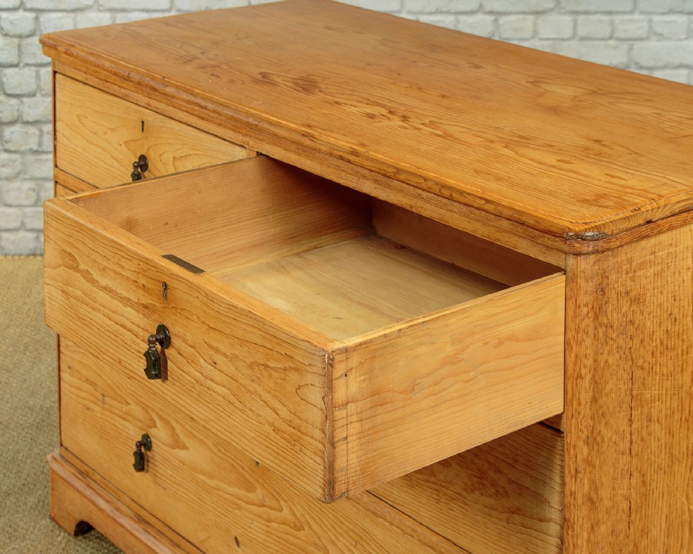 A late Victorian natural pine chest of drawers featuring a two short over two long drawer layout with brass drop handles. View VI