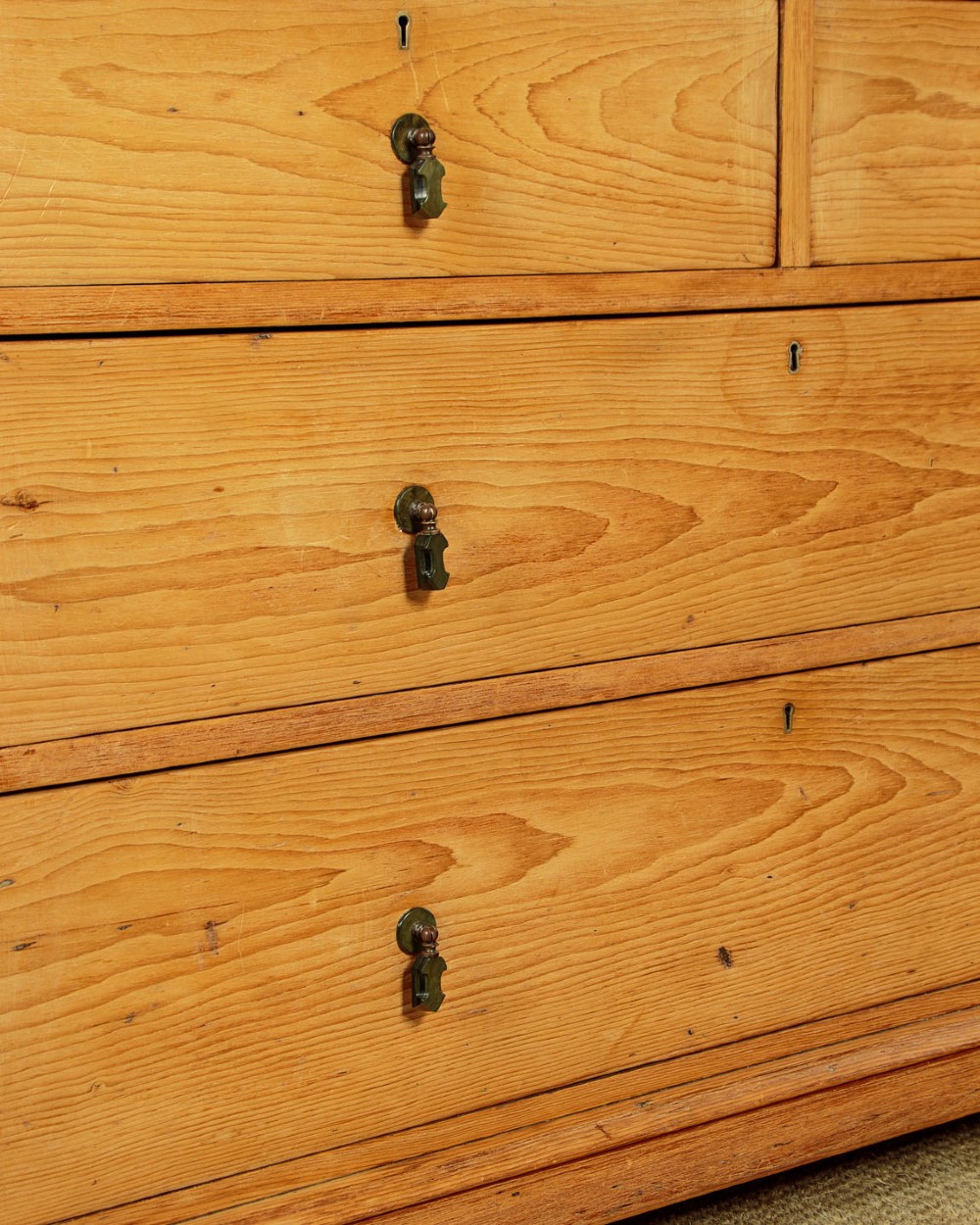 A late Victorian natural pine chest of drawers featuring a two short over two long drawer layout with brass drop handles. View VII