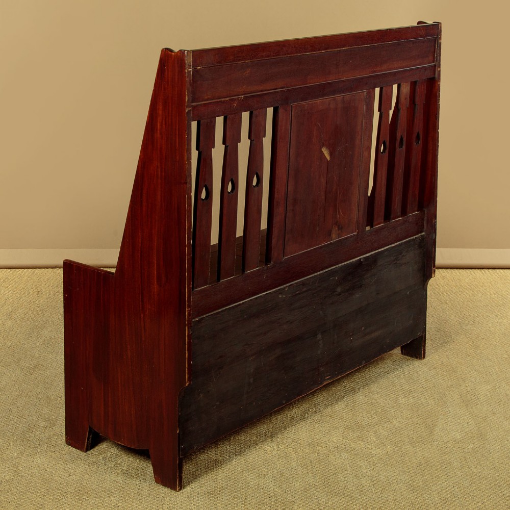 A dark mahogany high-back Arts and Crafts box settle featuring stylised floral marquetry inlay and vertical splat details above a hinged lift-up storage seat. View XI