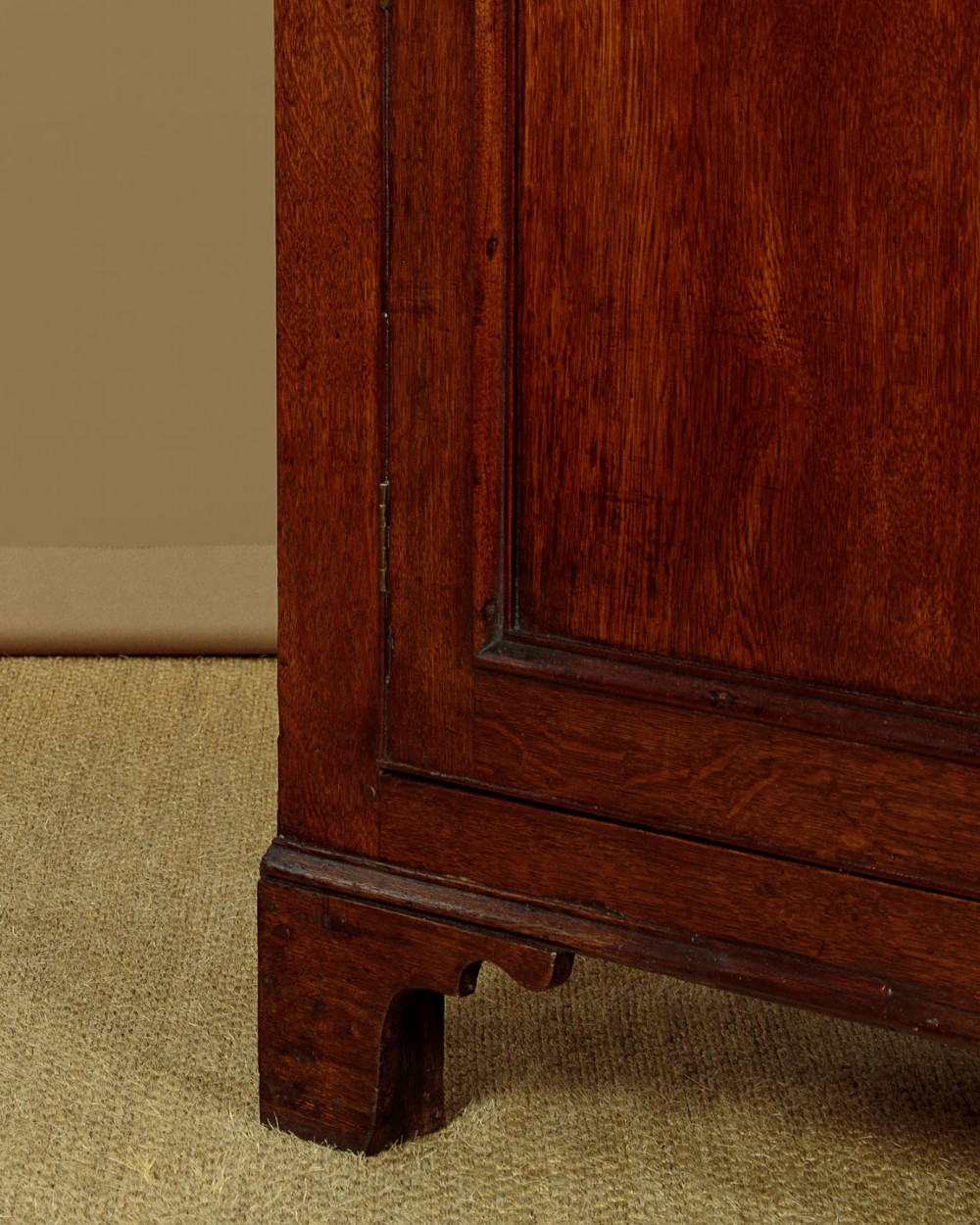 A two-section Georgian Welsh dark oak bread and cheese cupboard featuring upper panelled doors with fretwork ventilation grilles, two drawers, and a double-door lower section. View XI