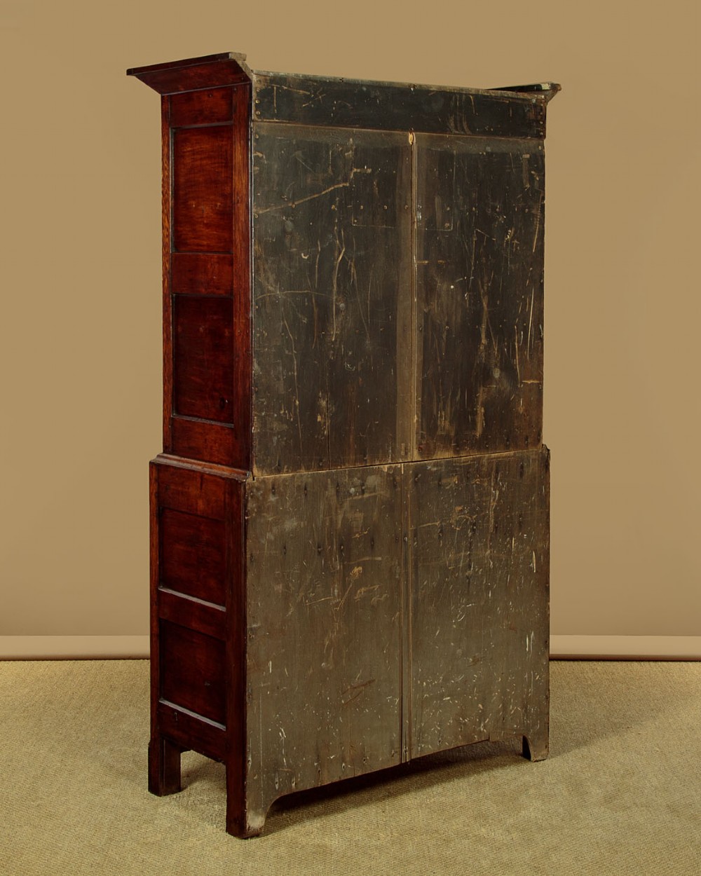 A two-section Georgian Welsh dark oak bread and cheese cupboard featuring upper panelled doors with fretwork ventilation grilles, two drawers, and a double-door lower section. View XII