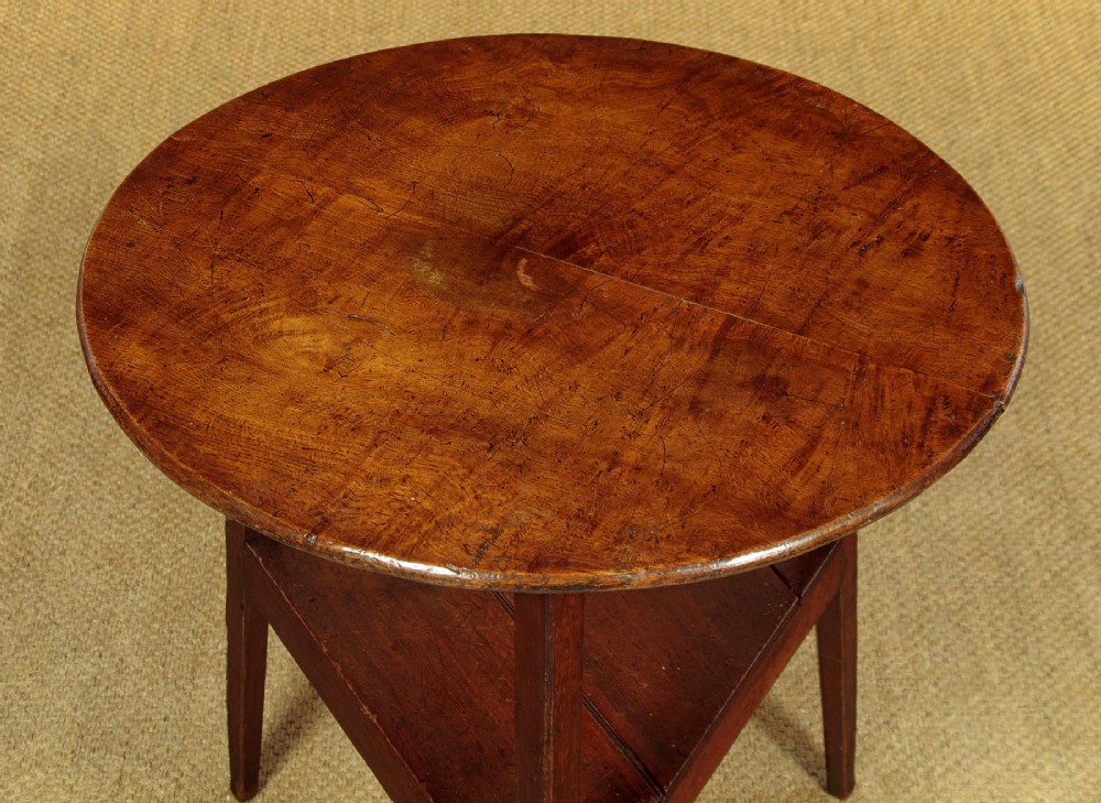 A mid-19th-century pollard oak cricket table with a round top, three splayed legs, and a triangular lower shelf. View III