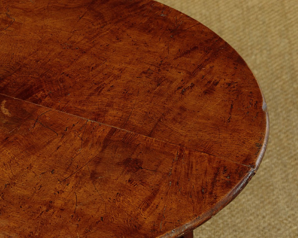 A mid-19th-century pollard oak cricket table with a round top, three splayed legs, and a triangular lower shelf. View IV