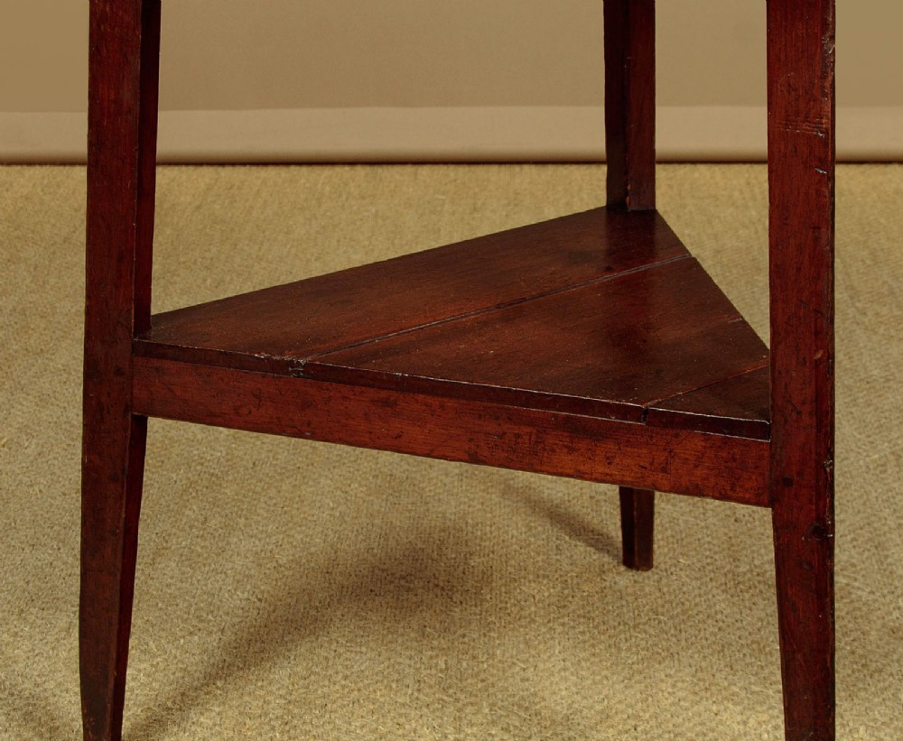 A mid-19th-century pollard oak cricket table with a round top, three splayed legs, and a triangular lower shelf. View VI