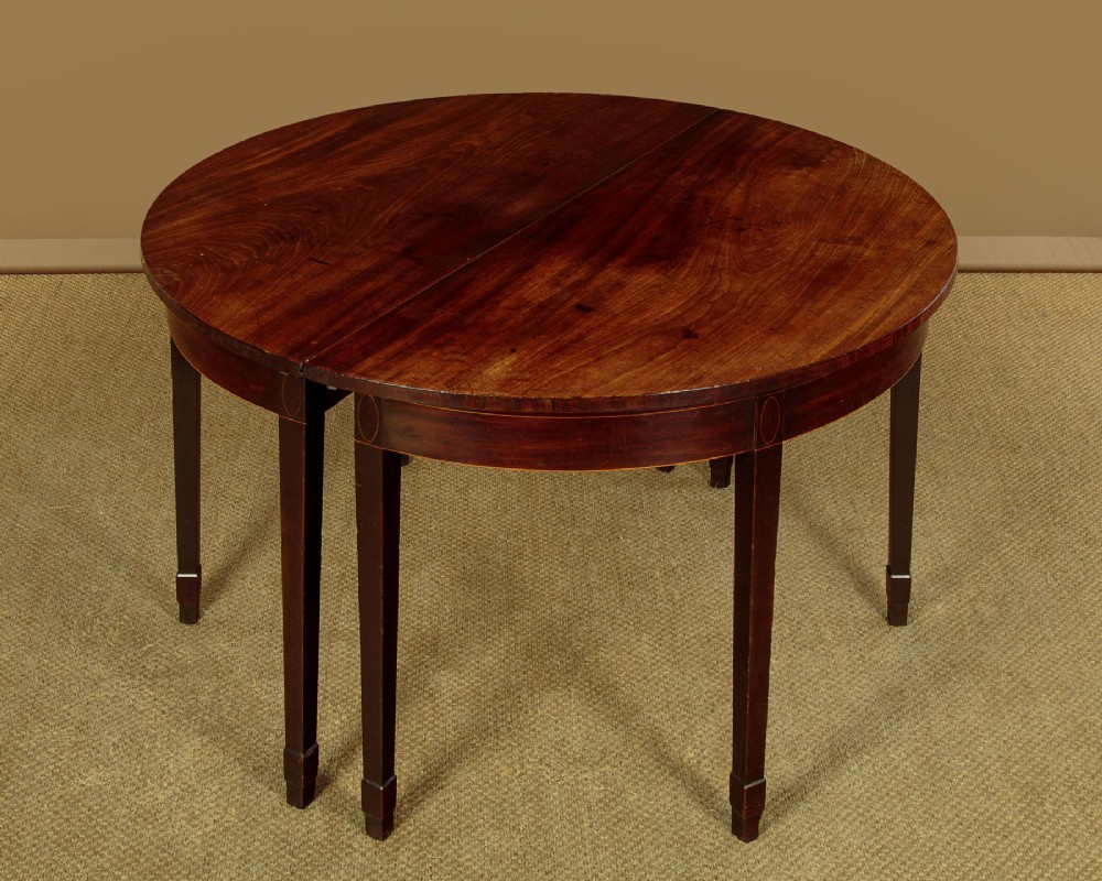 A pair of late George III mahogany demi-lune side tables featuring inlaid aprons and square tapered legs. View IV