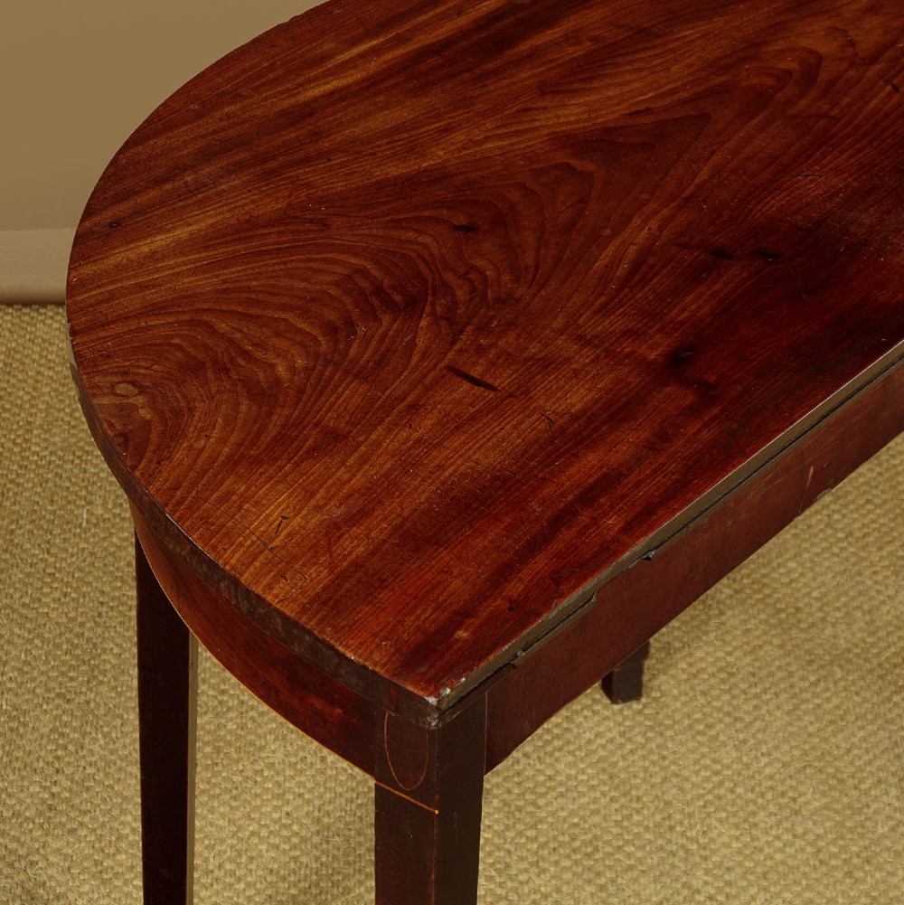 A pair of late George III mahogany demi-lune side tables featuring inlaid aprons and square tapered legs. View VII