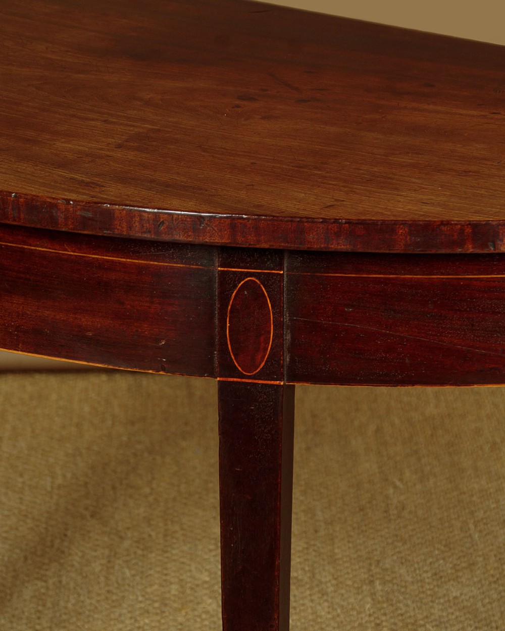 A pair of late George III mahogany demi-lune side tables featuring inlaid aprons and square tapered legs. View VIII