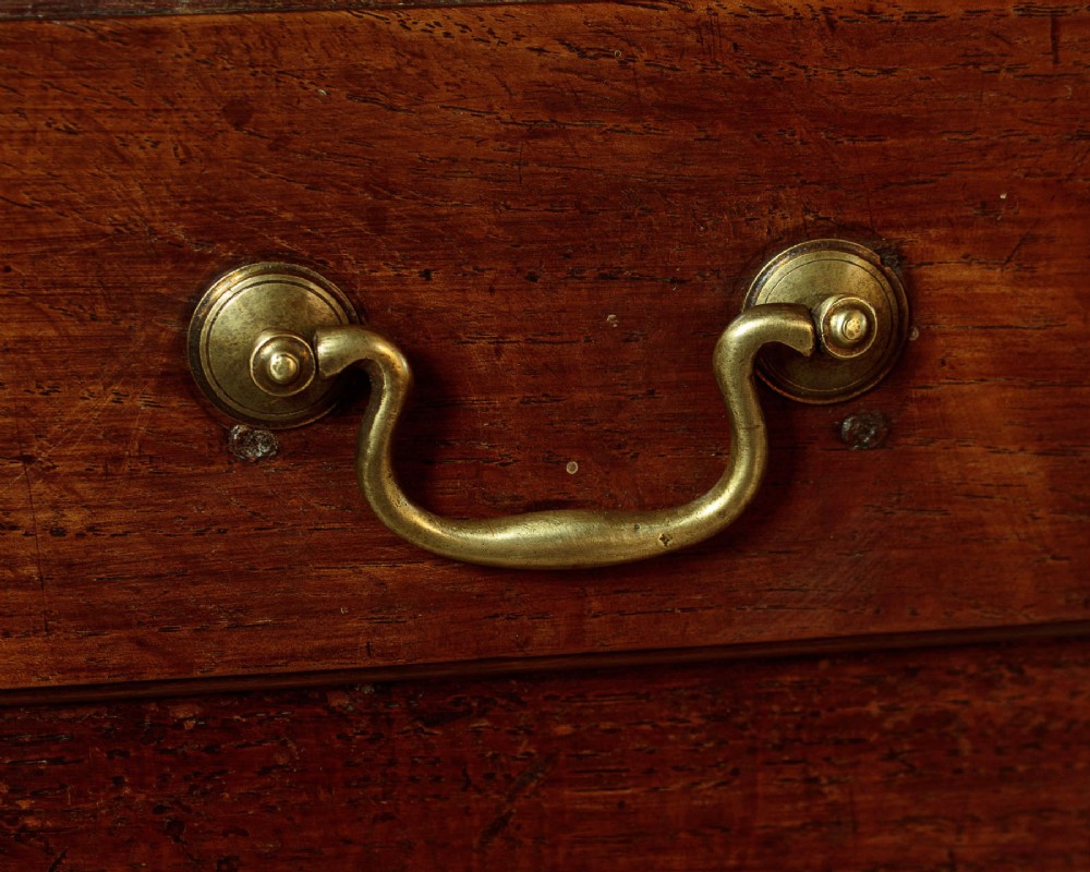 A George III dark oak potboard dresser base featuring three upper drawers, four frieze drawers, brass handles, shaped spandrels, and a low open shelf. View XI