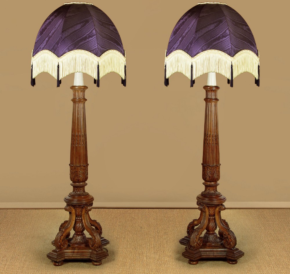 A pair of carved walnut standard lamps featuring fluted tapered shafts, acanthus scroll bases, and candle-style bulb sockets. View II