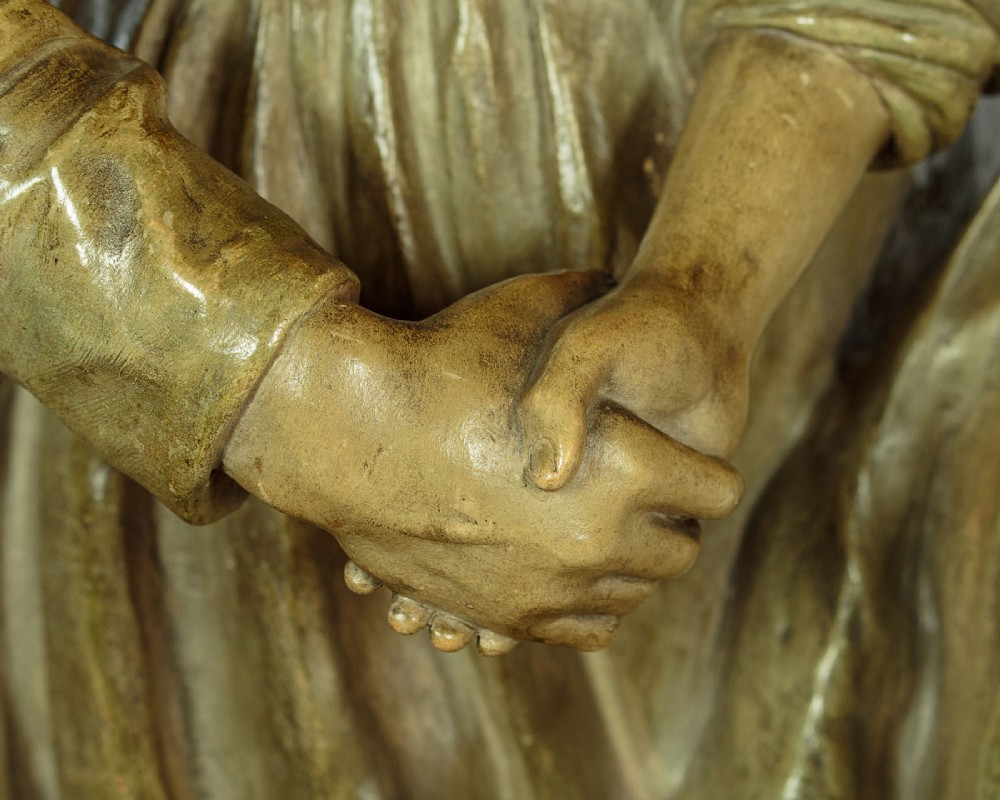 A patinated terracotta sculpture depicting a man and woman in traditional rural attire embracing while holding a woven basket. View VII