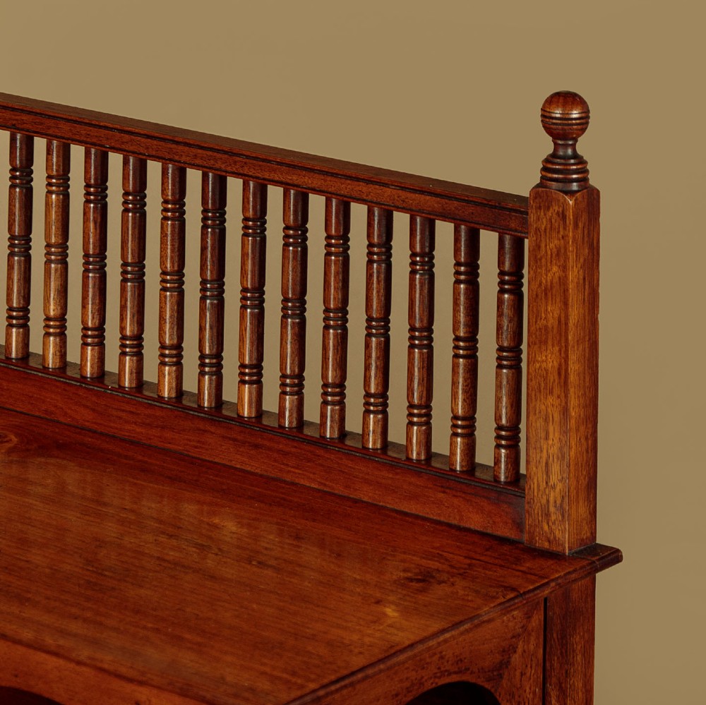 An Arts and Crafts oak side cabinet featuring an upper spindle gallery, arched open shelves, diagonal side struts, and a central cabinet door with leaded glass. View VI
