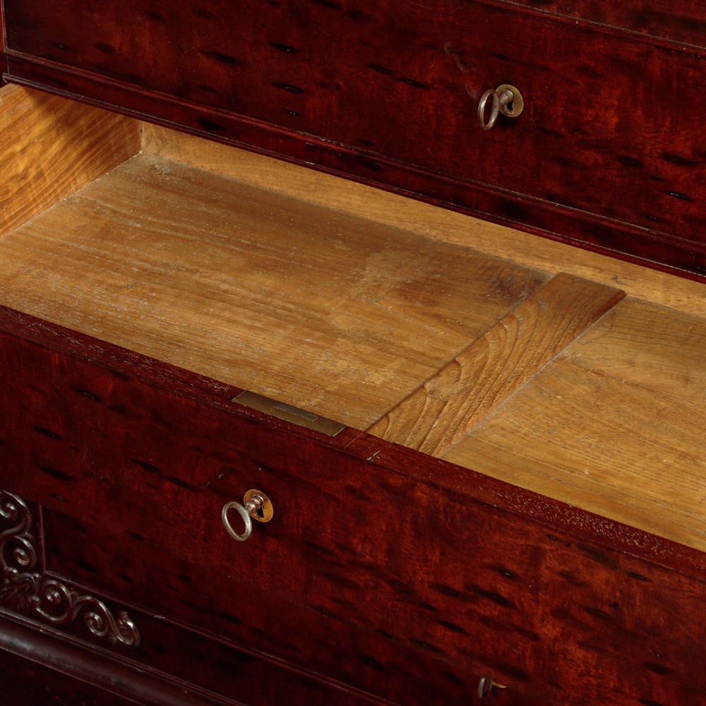 A mid-19th century French Louis Philippe mahogany chest of drawers featuring five stacked drawers, polished dark timber finish, brass keyhole escutcheons, and foliate carvings framing the corners. View VII