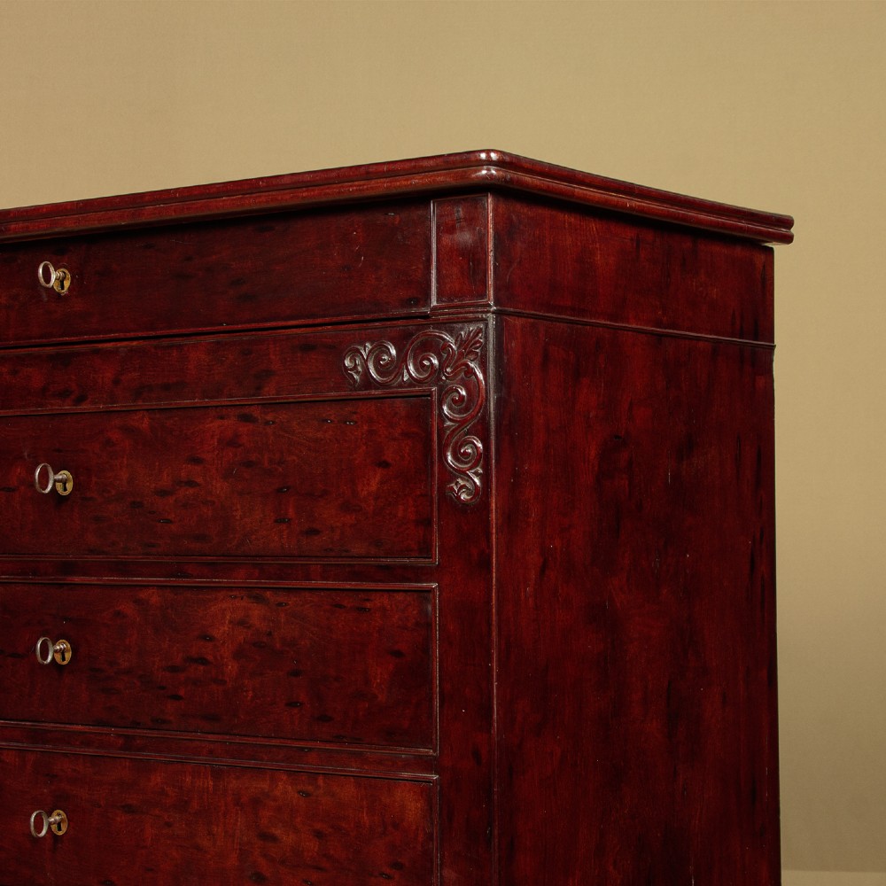 A mid-19th century French Louis Philippe mahogany chest of drawers featuring five stacked drawers, polished dark timber finish, brass keyhole escutcheons, and foliate carvings framing the corners. View VIII
