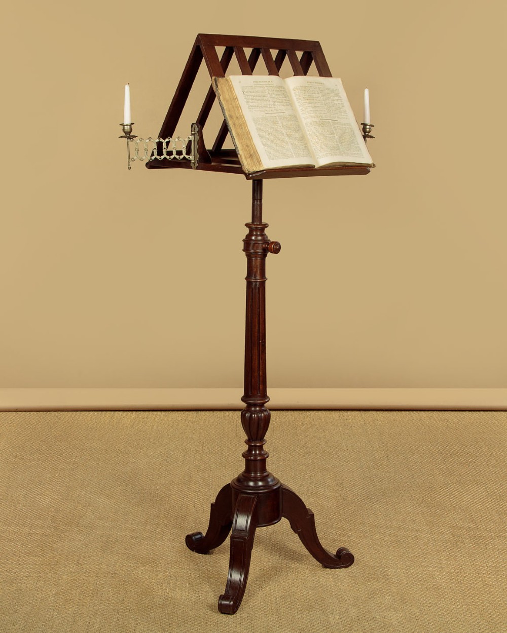 An antique dark mahogany duet music stand with a double-sided slatted rack, twin adjustable brass candle sconces, and a tripod base. View II