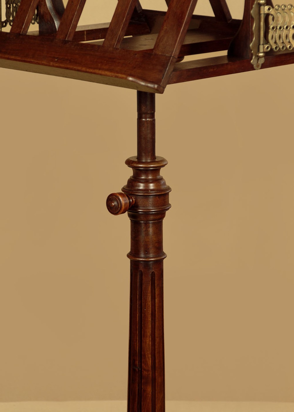 An antique dark mahogany duet music stand with a double-sided slatted rack, twin adjustable brass candle sconces, and a tripod base. View VII
