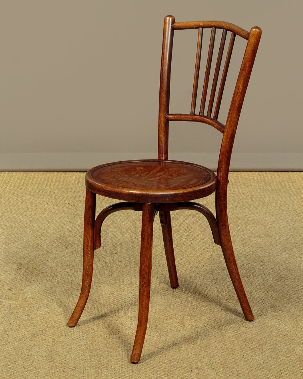 A set of four dark brown bentwood bistro dining chairs with vertical spindle backs, circular wooden seats, and curved legs. View II