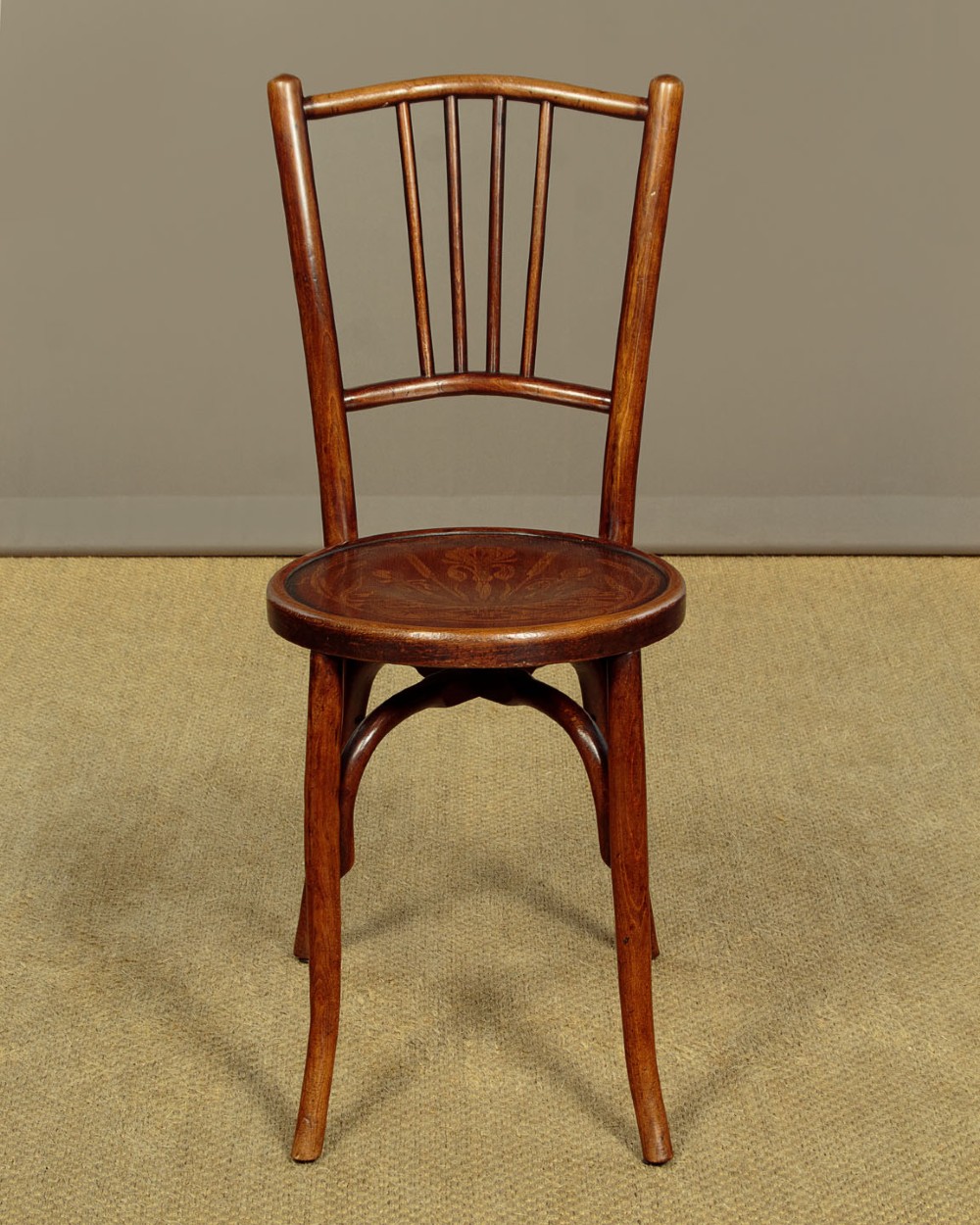 A set of four dark brown bentwood bistro dining chairs with vertical spindle backs, circular wooden seats, and curved legs. View III
