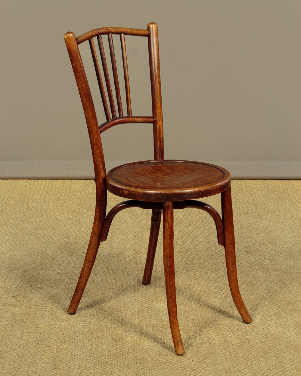 A set of four dark brown bentwood bistro dining chairs with vertical spindle backs, circular wooden seats, and curved legs. View IV