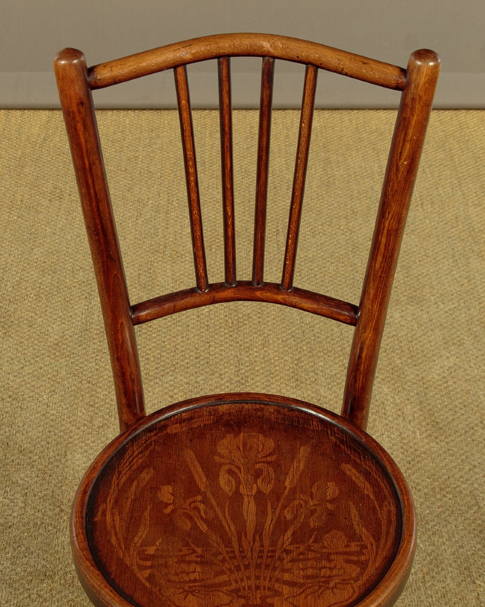 A set of four dark brown bentwood bistro dining chairs with vertical spindle backs, circular wooden seats, and curved legs. View VI