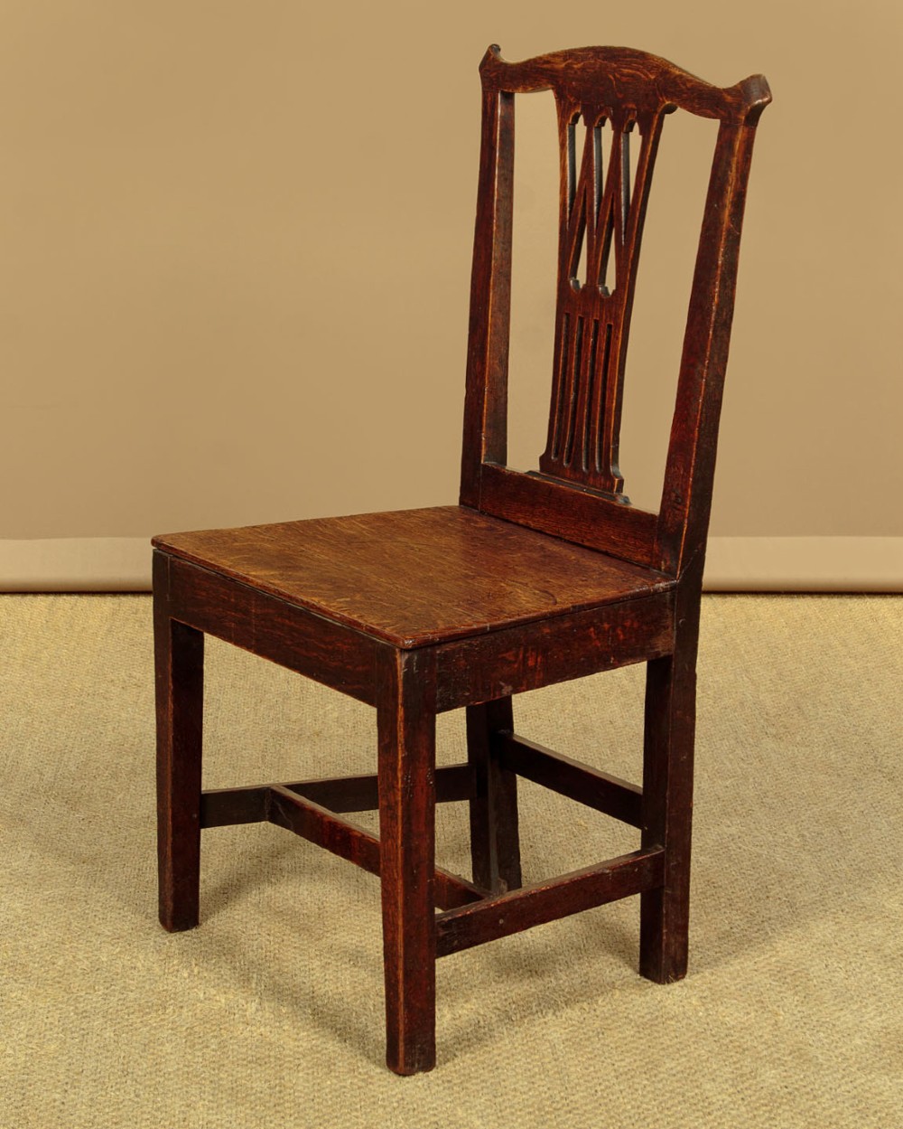 A set of six dark oak Country Chippendale dining chairs featuring pierced splat backs, solid seats, and square legs connected by stretchers. View II