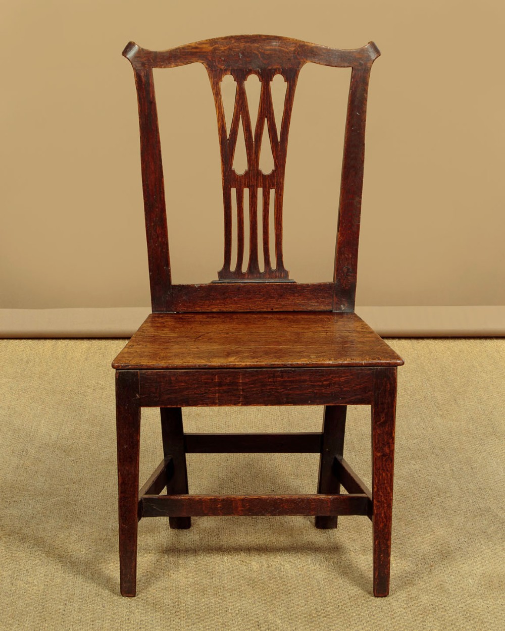A set of six dark oak Country Chippendale dining chairs featuring pierced splat backs, solid seats, and square legs connected by stretchers. View III