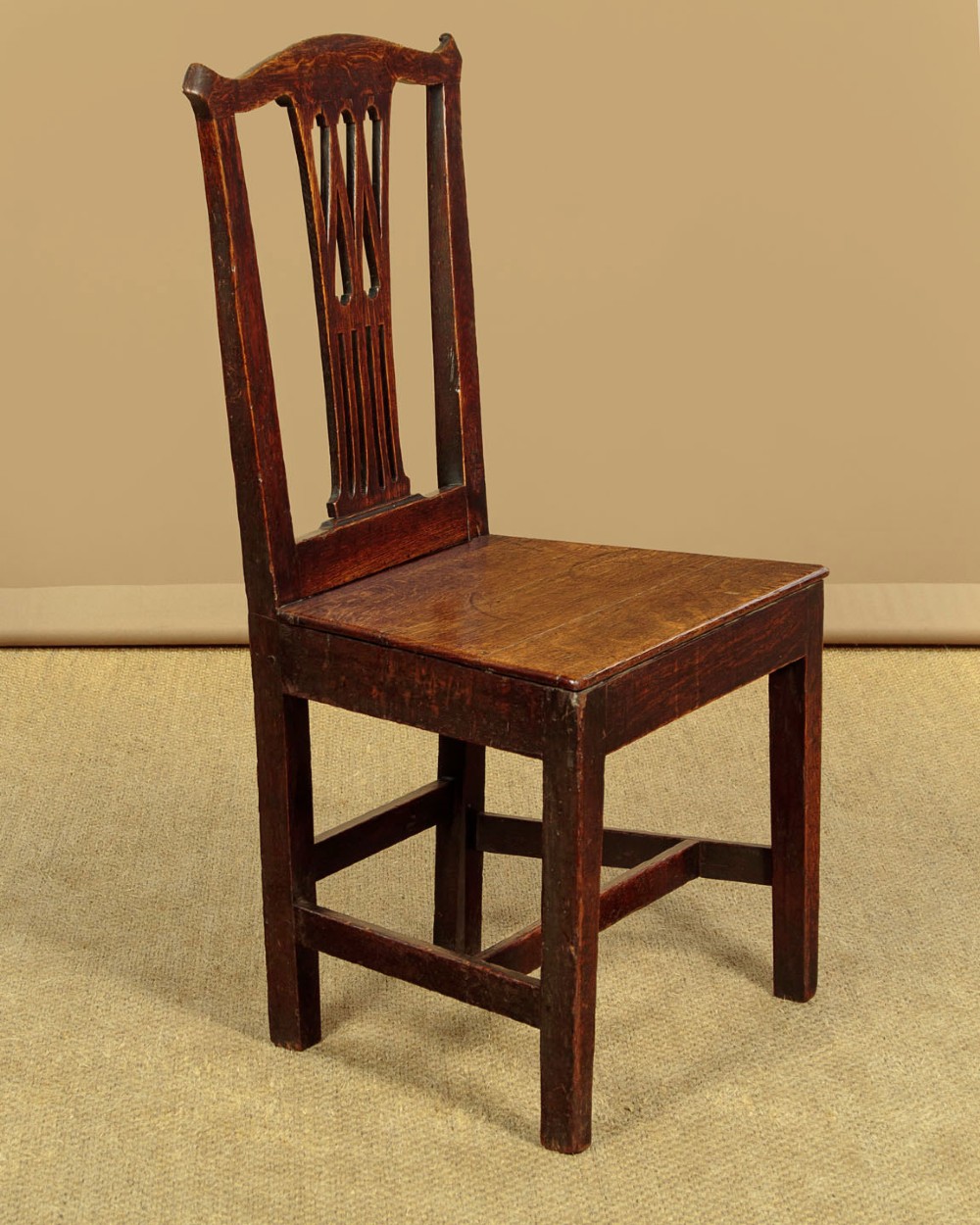 A set of six dark oak Country Chippendale dining chairs featuring pierced splat backs, solid seats, and square legs connected by stretchers. View IV