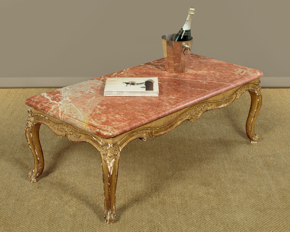 A low rectangular coffee table featuring a pink and red veined marble top supported by a carved giltwood frame with cabriole legs. View II