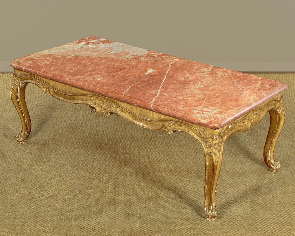 A low rectangular coffee table featuring a pink and red veined marble top supported by a carved giltwood frame with cabriole legs. View IV