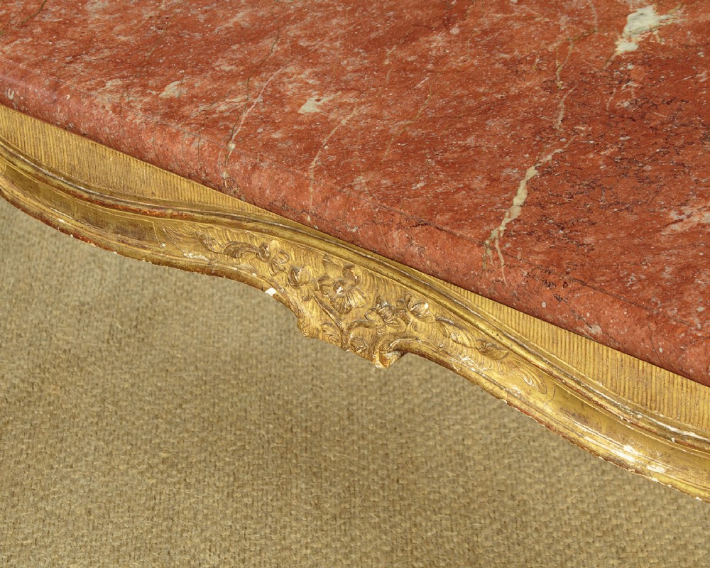 A low rectangular coffee table featuring a pink and red veined marble top supported by a carved giltwood frame with cabriole legs. View VIII