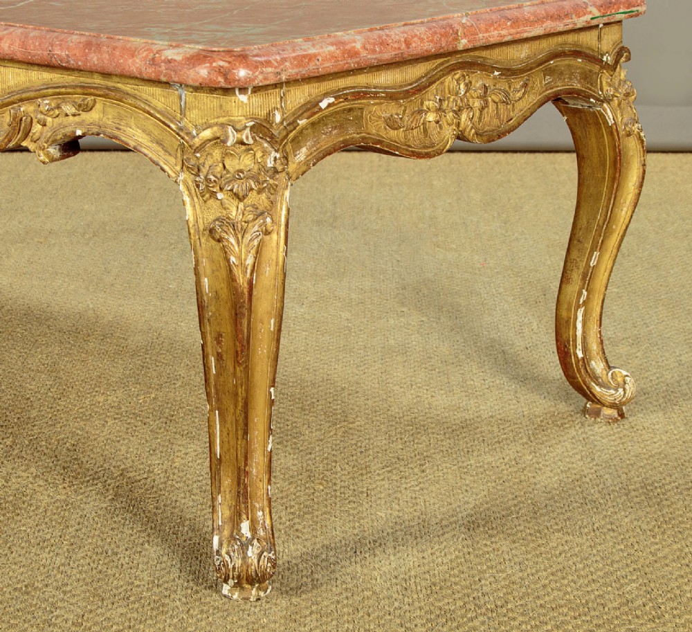A low rectangular coffee table featuring a pink and red veined marble top supported by a carved giltwood frame with cabriole legs. View IX