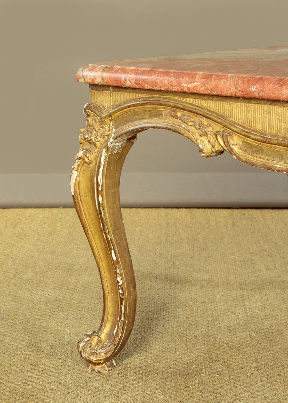 A low rectangular coffee table featuring a pink and red veined marble top supported by a carved giltwood frame with cabriole legs. View X