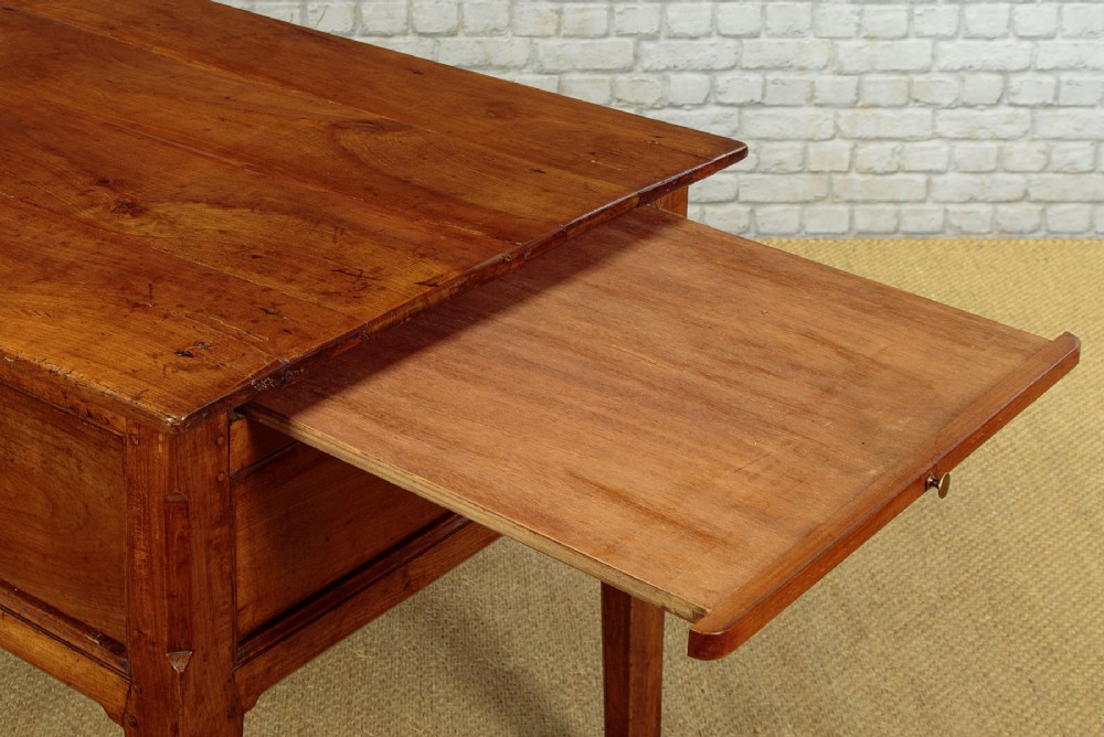 A mid-19th-century French cherry wood kitchen work table featuring three front drawers with brass handles and tapered square legs. View XI