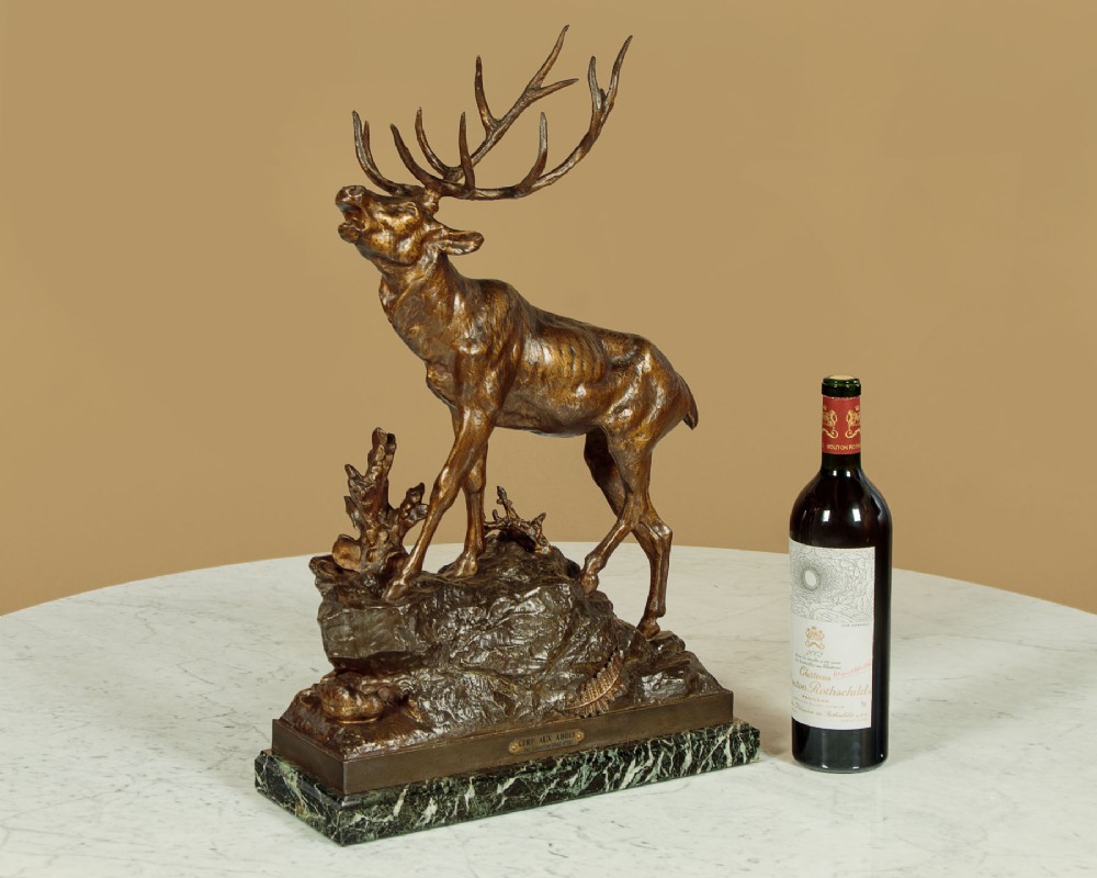 A bronze-patinated spelter sculpture depicting a bellowing stag on a rocky outcrop, mounted on a veined green marble base with a metallic title plaque. View II