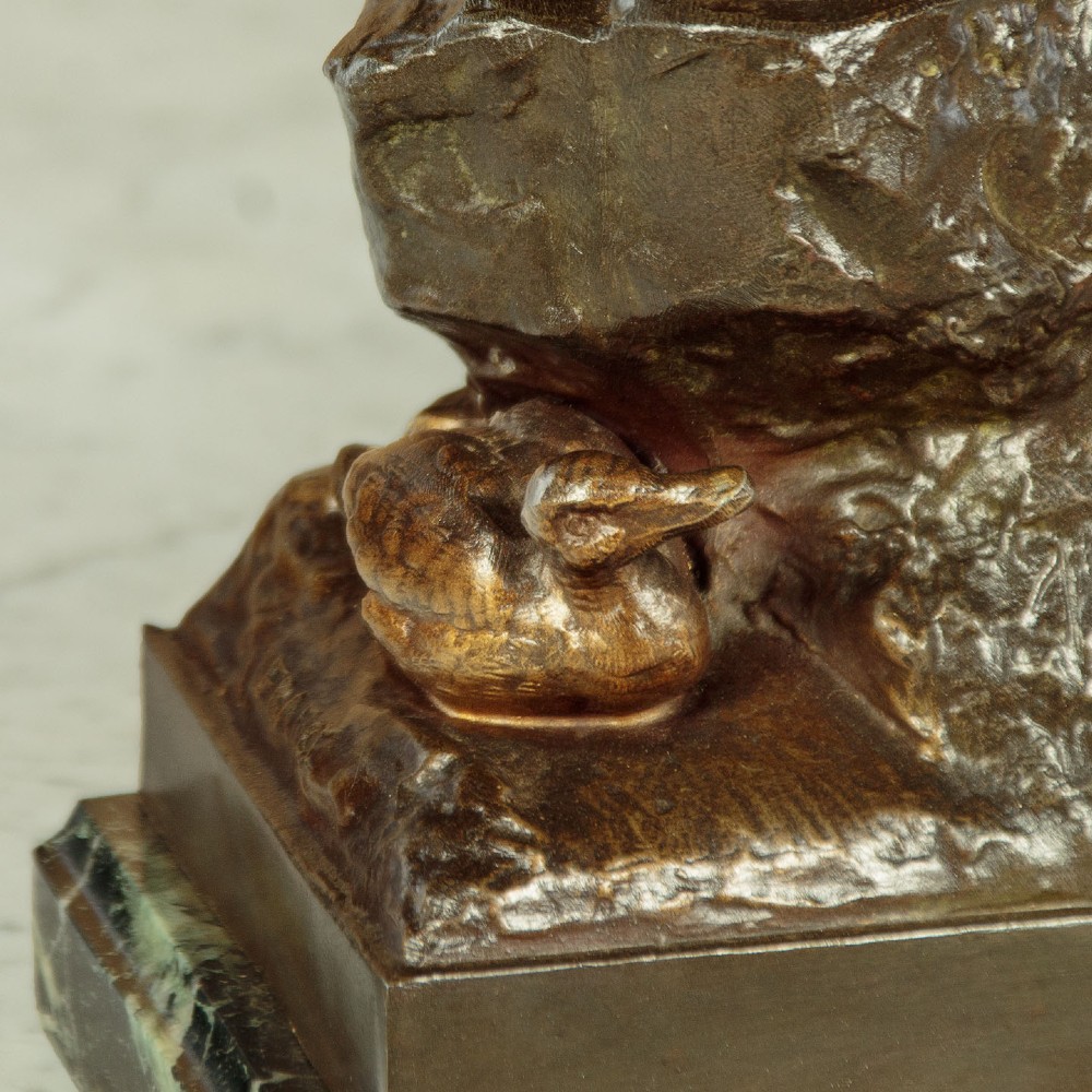 A bronze-patinated spelter sculpture depicting a bellowing stag on a rocky outcrop, mounted on a veined green marble base with a metallic title plaque. View VII