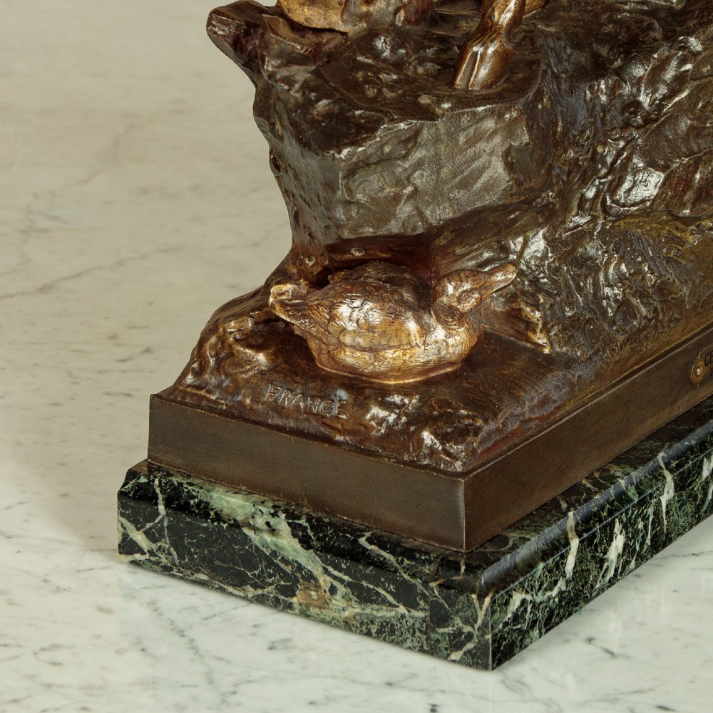 A bronze-patinated spelter sculpture depicting a bellowing stag on a rocky outcrop, mounted on a veined green marble base with a metallic title plaque. View VIII