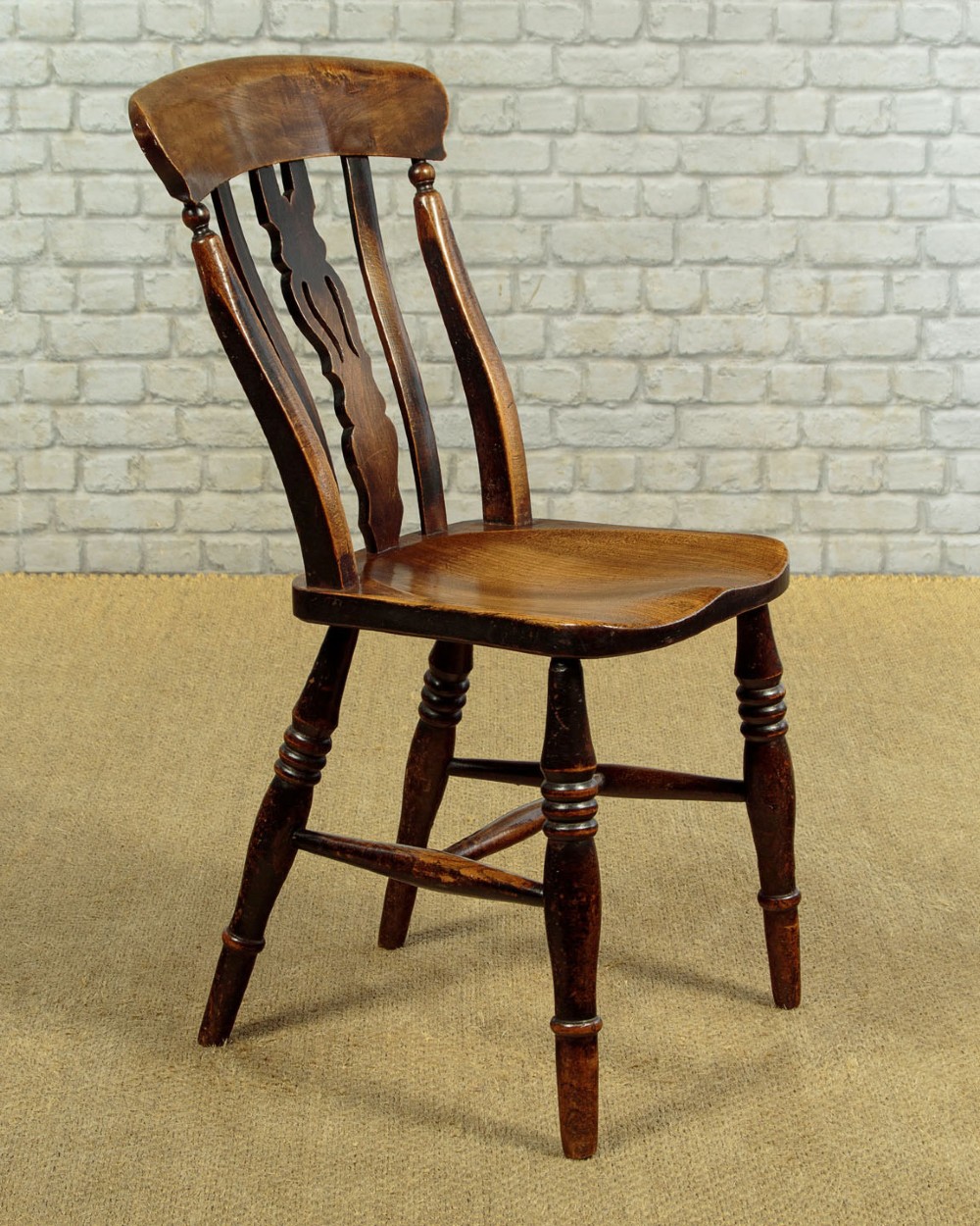 A set of four late 19th-century dark oak dining chairs featuring shaped back rails, pierced splats, contoured wooden seats, and turned legs with stretchers. View III