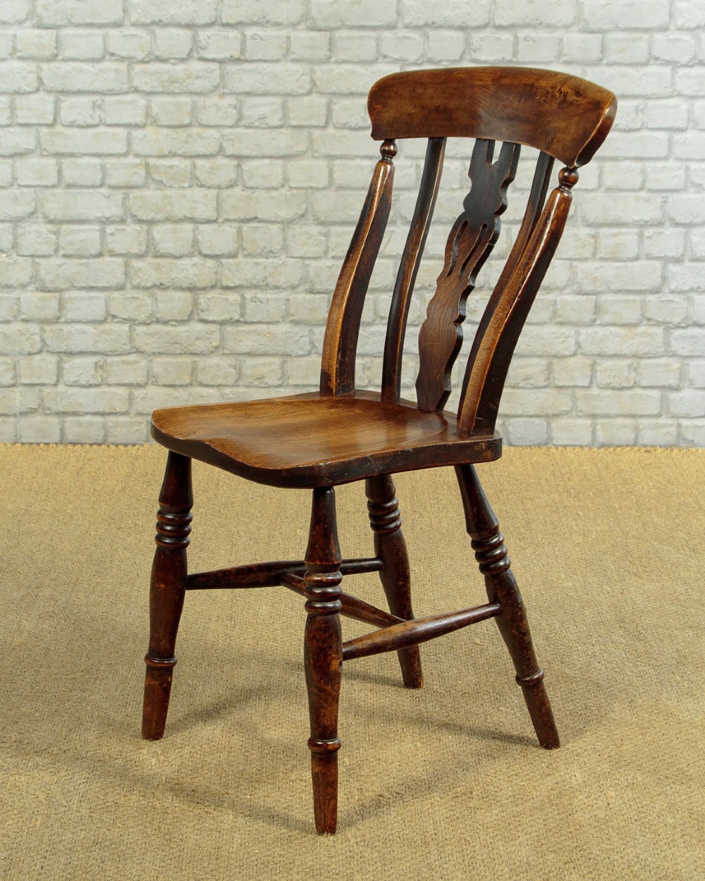 A set of four late 19th-century dark oak dining chairs featuring shaped back rails, pierced splats, contoured wooden seats, and turned legs with stretchers. View V