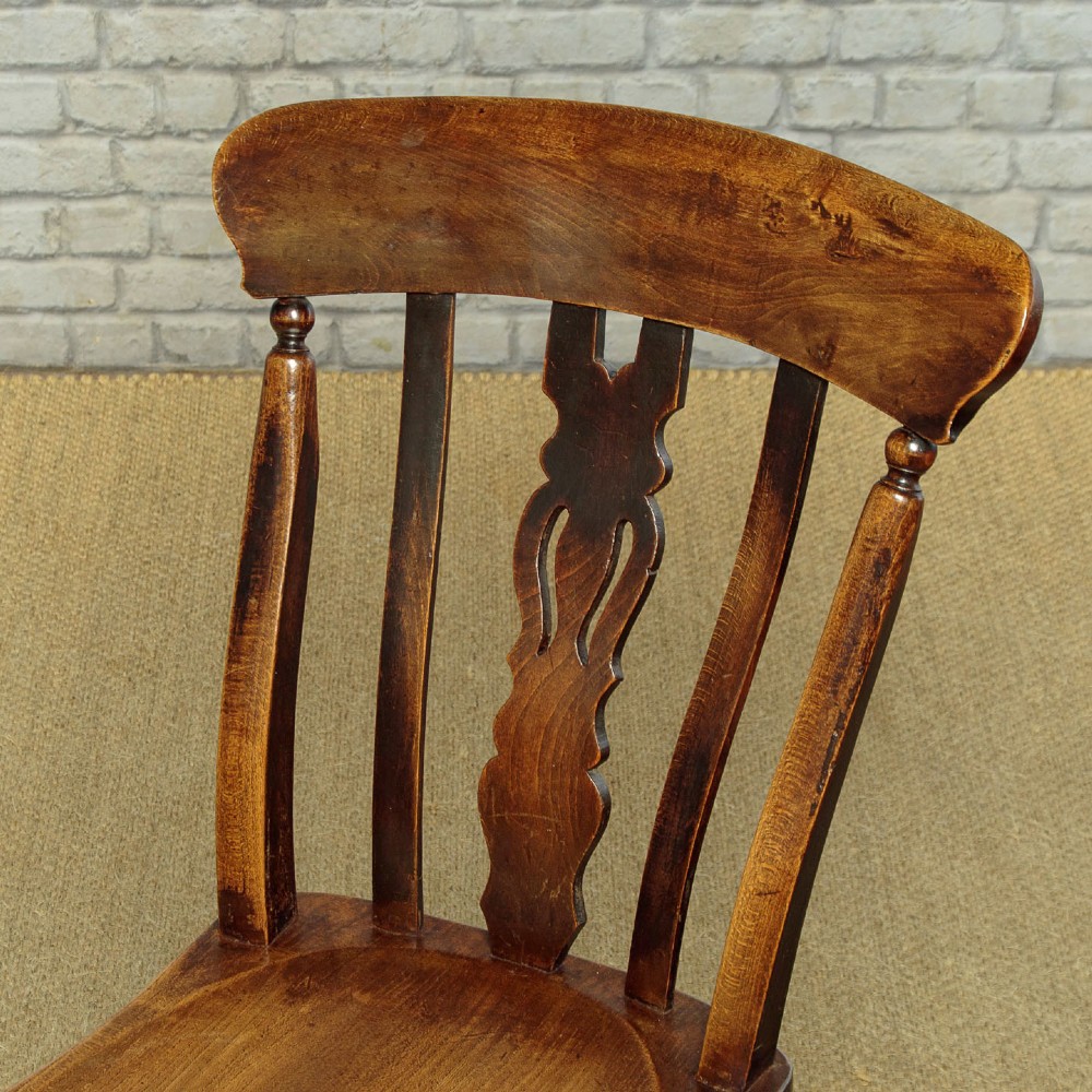 A set of four late 19th-century dark oak dining chairs featuring shaped back rails, pierced splats, contoured wooden seats, and turned legs with stretchers. View VI