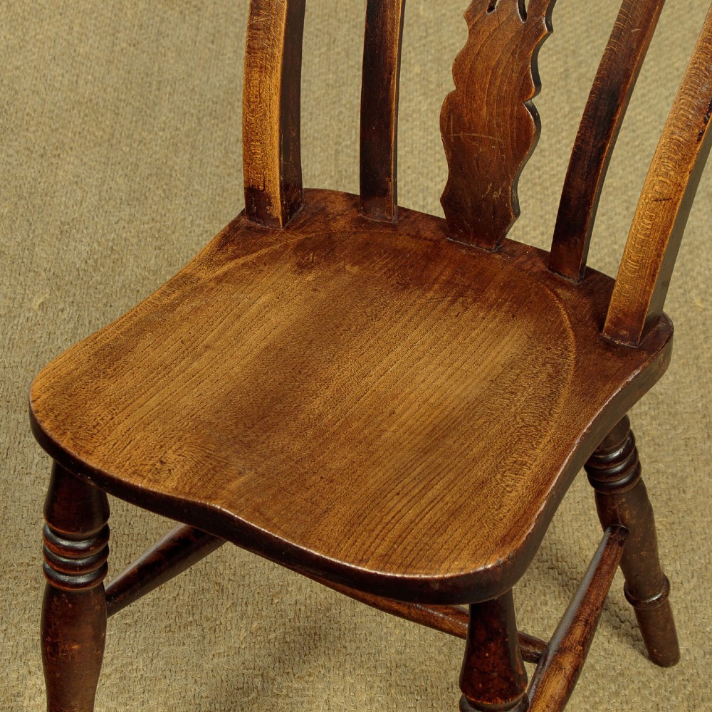 A set of four late 19th-century dark oak dining chairs featuring shaped back rails, pierced splats, contoured wooden seats, and turned legs with stretchers. View IX