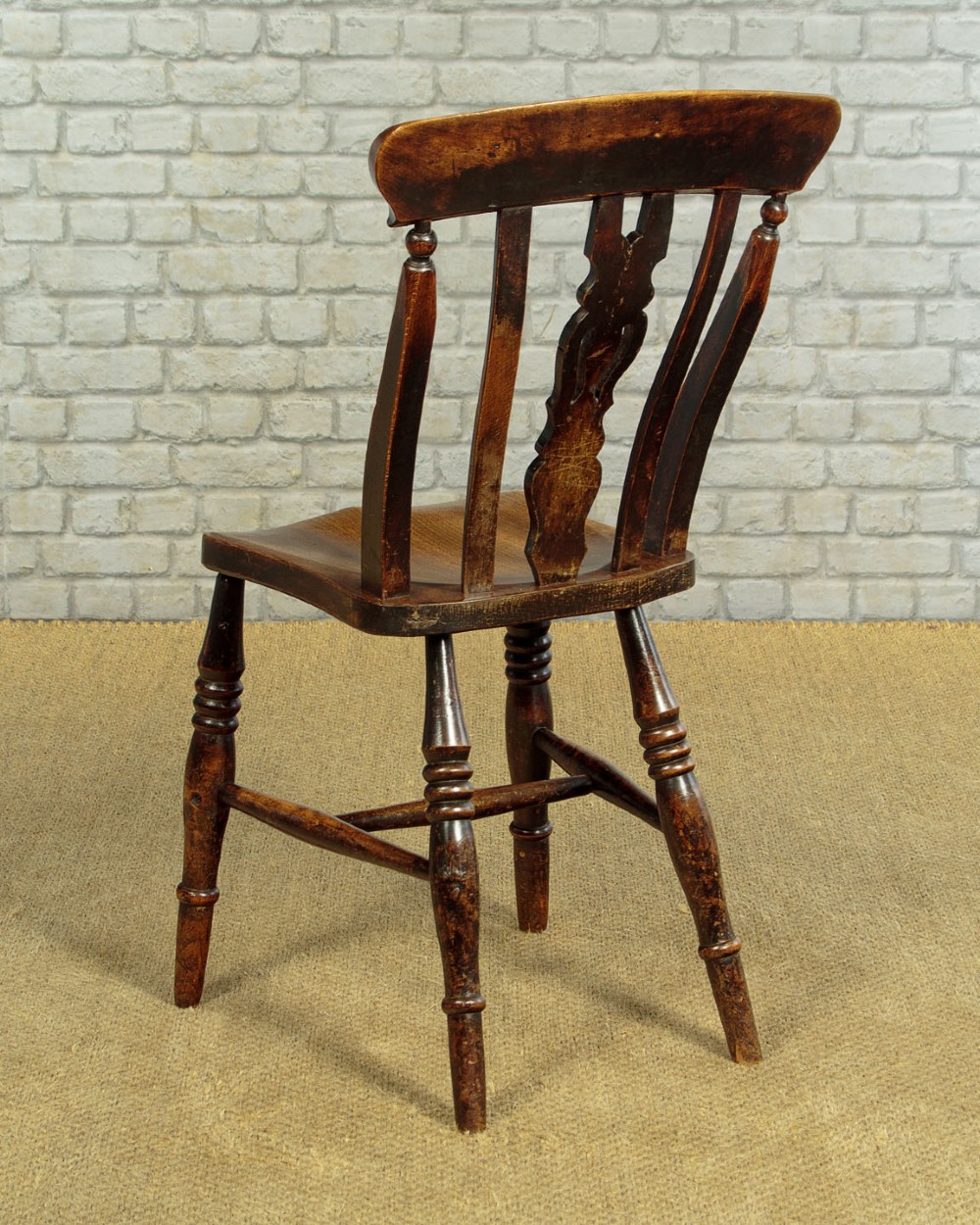 A set of four late 19th-century dark oak dining chairs featuring shaped back rails, pierced splats, contoured wooden seats, and turned legs with stretchers. View XII