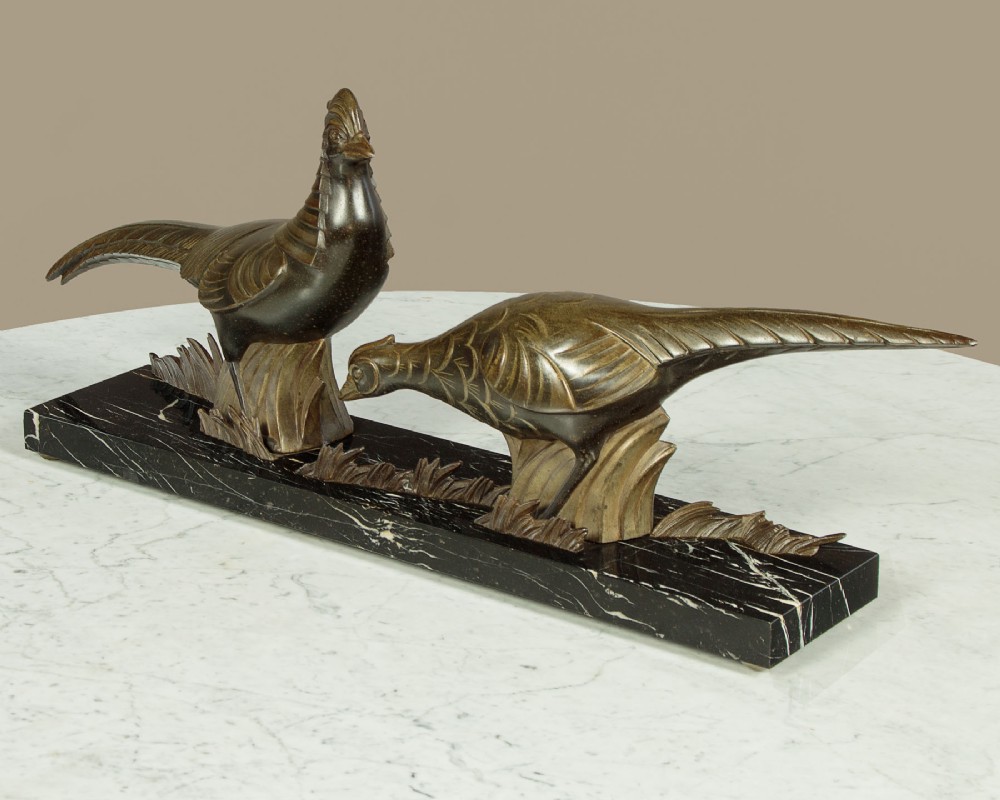 An Art Deco patinated metal sculpture featuring two stylised pheasants mounted on a rectangular black marble base with white veining. View III