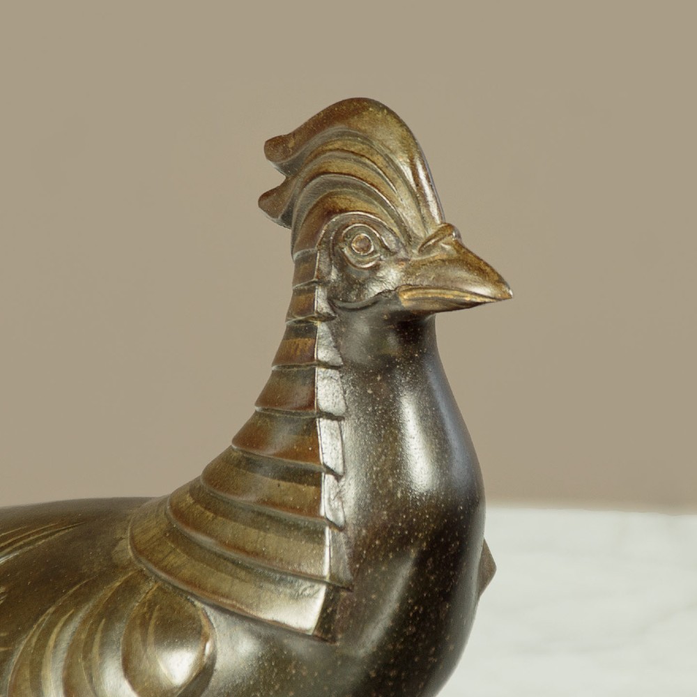 An Art Deco patinated metal sculpture featuring two stylised pheasants mounted on a rectangular black marble base with white veining. View IV