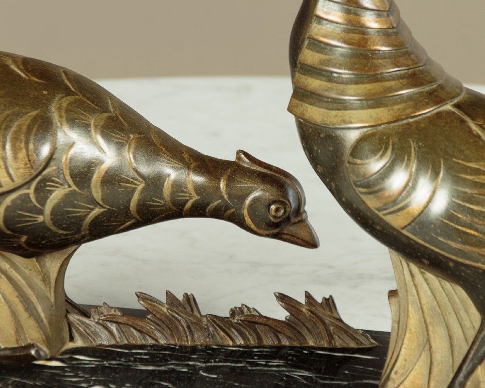 An Art Deco patinated metal sculpture featuring two stylised pheasants mounted on a rectangular black marble base with white veining. View VI