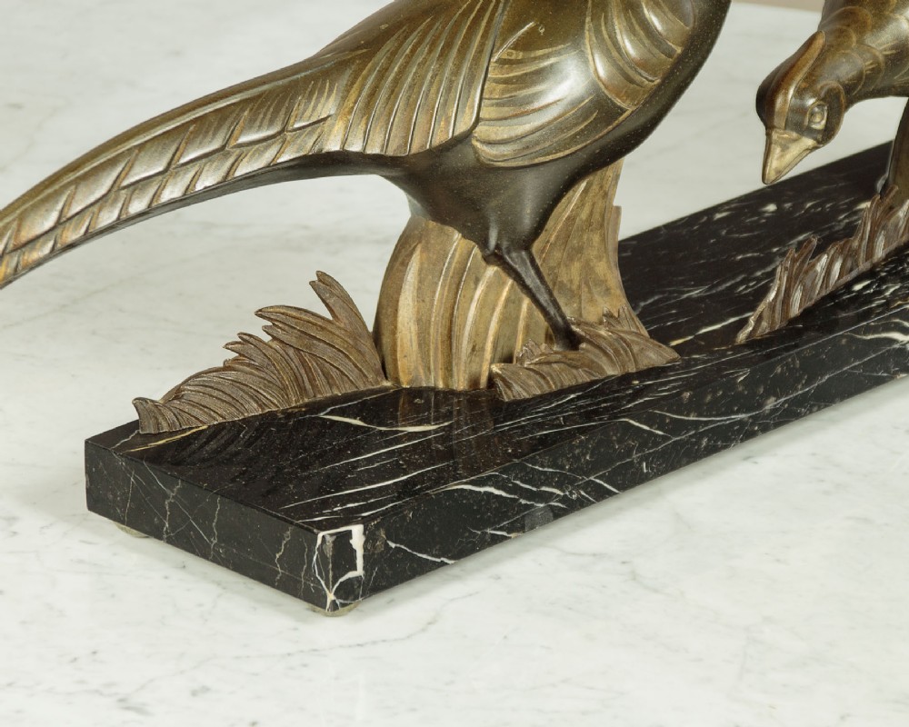 An Art Deco patinated metal sculpture featuring two stylised pheasants mounted on a rectangular black marble base with white veining. View VIII
