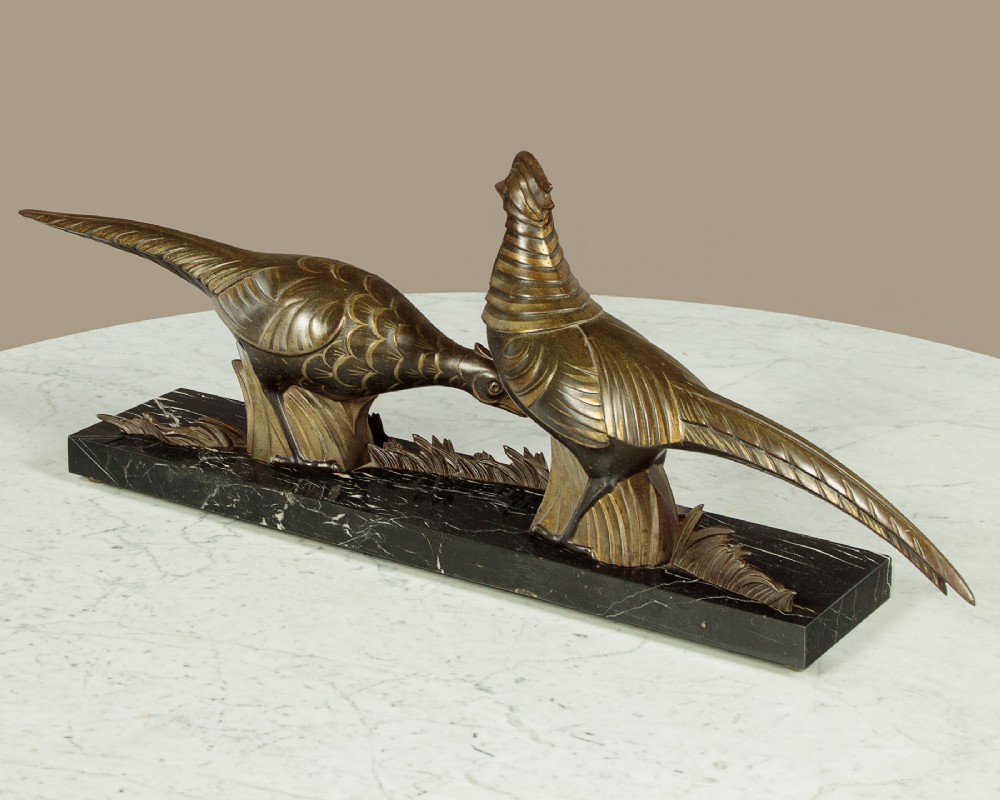 An Art Deco patinated metal sculpture featuring two stylised pheasants mounted on a rectangular black marble base with white veining. View IX